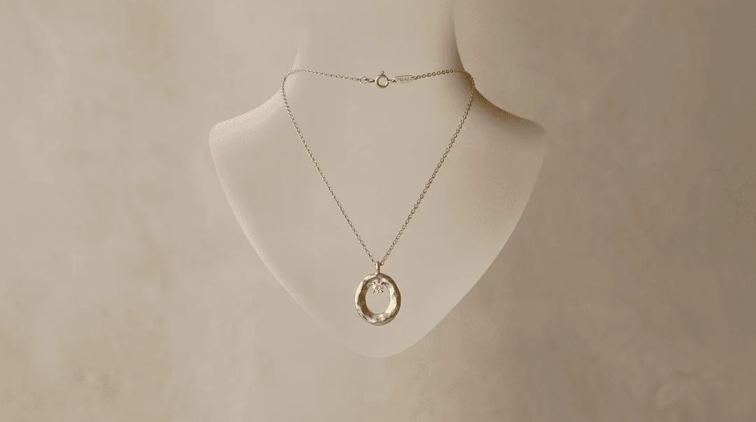 Gold pendant necklace floating in an invisible mannequin bust shape