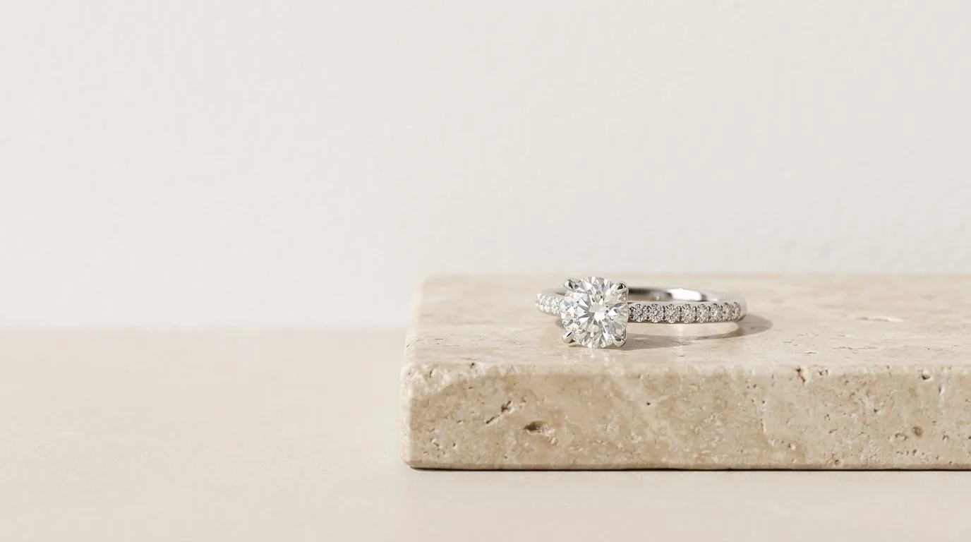 White gold diamond ring on travertine block comparing high-fidelity AI jewelry photography