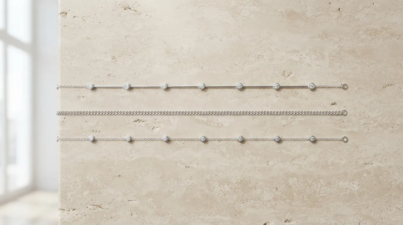 Clean minimal flat lay of three thin silver bracelets arranged parallel on a beige backdrop
